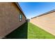 Long and narrow backyard with synthetic turf and a tan stucco wall at 2229 N 139Th Dr, Goodyear, AZ 85395
