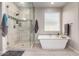 This bathroom features a modern bathtub with a walk-in glass shower and tiled floors at 2229 N 139Th Dr, Goodyear, AZ 85395