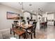 Inviting dining area with modern chandelier, rustic wooden table and bench, and views of the gourmet kitchen at 2229 N 139Th Dr, Goodyear, AZ 85395