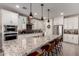 Gourmet kitchen featuring white cabinets, stainless steel appliances, and a granite island countertop with barstool seating at 2229 N 139Th Dr, Goodyear, AZ 85395
