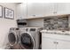 Laundry room features a washer and dryer with white storage cabinets at 2229 N 139Th Dr, Goodyear, AZ 85395