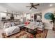 Bright open concept featuring the living room with a ceiling fan connected to the gourmet kitchen with a large kitchen island at 2229 N 139Th Dr, Goodyear, AZ 85395