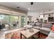 Open-concept living room with sliding glass doors to patio, neutral tones, and seamless connection to the kitchen and dining area at 2229 N 139Th Dr, Goodyear, AZ 85395