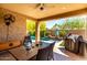 Covered patio featuring a ceiling fan, outdoor dining set, and access to the pool at 2229 N 139Th Dr, Goodyear, AZ 85395