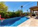 Backyard pool with mature landscaping, outdoor seating area, and a built-in water feature at 2229 N 139Th Dr, Goodyear, AZ 85395