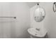 Simple powder room features a pedestal sink, round mirror, and neutral decor at 2337 E Fraktur Rd, Phoenix, AZ 85040