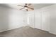 A cozy bedroom with neutral carpet, white walls, ceiling fan, closet and access ways at 2337 E Fraktur Rd, Phoenix, AZ 85040