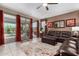 Bright living room featuring tile floors, oversized windows, and leather sofa at 23707 W Hess Ave, Buckeye, AZ 85326