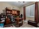 Home office with a large desk, built-in shelves, and comfortable seating for a productive workspace at 23707 W Hess Ave, Buckeye, AZ 85326
