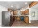 Open-concept kitchen with wood cabinets, stainless steel refrigerator, and blue dishwasher at 2388 S Vista Rd, Apache Junction, AZ 85119