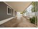 Long, covered patio with grey siding and a concrete floor extending to the backyard at 2388 S Vista Rd, Apache Junction, AZ 85119