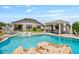 Inviting backyard featuring a sparkling pool, rock accents, and a shaded pergola with comfortable seating at 25421 S 228Th St, Queen Creek, AZ 85142