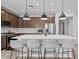 Well-equipped kitchen island with stainless steel appliances, pendant lights, and barstool seating at 25421 S 228Th St, Queen Creek, AZ 85142