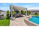 Outdoor entertainment area featuring a pergola with a TV, lounge seating, and a swimming pool at 25421 S 228Th St, Queen Creek, AZ 85142