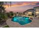 Serene backyard with a shimmering pool, swaying palms, and cozy seating area under the covered patio at 25421 S 228Th St, Queen Creek, AZ 85142