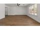 Spacious living area featuring wood-look flooring, a ceiling fan, and a large window with shutters at 271 W Roadrunner Dr, Chandler, AZ 85286