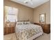 Cozy bedroom features a floral patterned bedspread, wood furniture, and natural light at 3152 E San Pedro Ct, Gilbert, AZ 85234