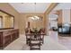 Formal dining room with a wooden table, upholstered chairs, chandelier lighting and earth-toned walls at 3152 E San Pedro Ct, Gilbert, AZ 85234
