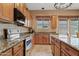 Well lit kitchen with stainless steel appliances, wooden cabinets, granite countertops and a large island at 3152 E San Pedro Ct, Gilbert, AZ 85234