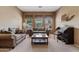 Cozy living room with sofas, carpeted floors, large windows, and a ship model on the wall at 3152 E San Pedro Ct, Gilbert, AZ 85234