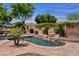 Relaxing backyard pool area with waterfall feature, lush landscaping, and ample patio space at 3152 E San Pedro Ct, Gilbert, AZ 85234