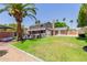 Spacious backyard featuring lush green grass, a hot tub, and mature palm trees, creating a serene outdoor retreat at 3377 W Grandview Rd, Phoenix, AZ 85053
