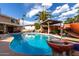 Gorgeous pool with covered patio, water feature and mature palm trees in backyard at 3377 W Grandview Rd, Phoenix, AZ 85053