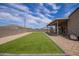 Backyard with a covered patio, turf lawn, and rock landscaping, offering a low-maintenance outdoor space at 34834 N Surrey Ln, San Tan Valley, AZ 85140