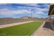 Backyard featuring artificial turf, rock landscaping, and a covered patio with outdoor seating at 34834 N Surrey Ln, San Tan Valley, AZ 85140