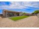 Spacious backyard with artificial turf, rock landscaping, and a covered patio, perfect for entertaining at 34834 N Surrey Ln, San Tan Valley, AZ 85140