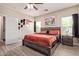 Comfortable bedroom featuring a wooden bed frame, ceiling fan and wood flooring at 34834 N Surrey Ln, San Tan Valley, AZ 85140