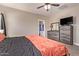 A bedroom featuring tiled flooring, a ceiling fan, and dressers with gray wood trim at 34834 N Surrey Ln, San Tan Valley, AZ 85140