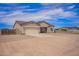 Single-story home with a two-car garage, desert landscaping, and long driveway at 34834 N Surrey Ln, San Tan Valley, AZ 85140