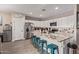 Bright kitchen featuring a breakfast bar, granite countertops, stainless steel appliances, and white cabinets at 34834 N Surrey Ln, San Tan Valley, AZ 85140