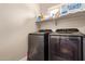 Modern laundry room equipped with washer, dryer, and shelving for storage at 34834 N Surrey Ln, San Tan Valley, AZ 85140