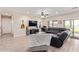 Open-concept living room featuring wood-look tile, plush seating, and seamless flow to the outdoor living space at 34834 N Surrey Ln, San Tan Valley, AZ 85140