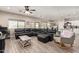 Spacious living room featuring wood-look tile, plush furniture, and lots of natural light at 34834 N Surrey Ln, San Tan Valley, AZ 85140