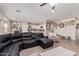 Open-concept living room featuring wood-look tile, plush seating, and seamless flow to the kitchen and dining areas at 34834 N Surrey Ln, San Tan Valley, AZ 85140