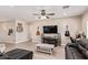 Comfortable living room with ceiling fan, guitars, mounted TV, and tile floors at 34834 N Surrey Ln, San Tan Valley, AZ 85140