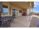 This covered patio includes a dining area and grill, with stone landscaping accents and outdoor lighting at 34834 N Surrey Ln, San Tan Valley, AZ 85140