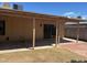 This backyard boasts a covered patio area with a concrete and brick surface, and a lush lawn at 3779 E Sweetwater Ave, Phoenix, AZ 85032