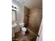 Bathroom with a pedestal sink, toilet, and tiled walk-in shower with custom shelving at 3779 E Sweetwater Ave, Phoenix, AZ 85032