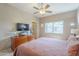 Well-lit bedroom featuring a ceiling fan, and ample storage space with a dresser and adjacent doorway at 3830 E Lakewood Pkwy # 1051, Phoenix, AZ 85048