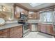 Stylish kitchen with stainless appliances, dark wood cabinets, and tile flooring offers a modern cooking space at 3830 E Lakewood Pkwy # 1051, Phoenix, AZ 85048