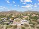 High angle shot of a desert community featuring houses, trees, and rolling hills in the background at 4111 N Starry Pass Cir, Mesa, AZ 85207