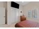 Bedroom with television, white walls, closet, and light colored carpet at 4111 N Starry Pass Cir, Mesa, AZ 85207