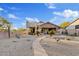 Exterior view of house featuring a backyard with desert landscaping and a charming spiral staircase to a roof deck at 4111 N Starry Pass Cir, Mesa, AZ 85207