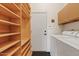 Bright laundry area with white machines, shelving, and exterior access door at 4111 N Starry Pass Cir, Mesa, AZ 85207