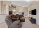 Spacious living room featuring a comfortable brown sectional sofa and neutral decor with a ceiling fan and vaulted ceilings at 4111 N Starry Pass Cir, Mesa, AZ 85207