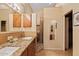 Bathroom with a double sink vanity, granite countertop, mirrors, decorative lighting, and a tiled shower at 4111 N Starry Pass Cir, Mesa, AZ 85207
